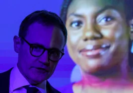 El diputado del Partido Conservador y candidato a líder Tom Tugendhat asiste a un evento en el que se muestra una foto de Kemi Badenoch.