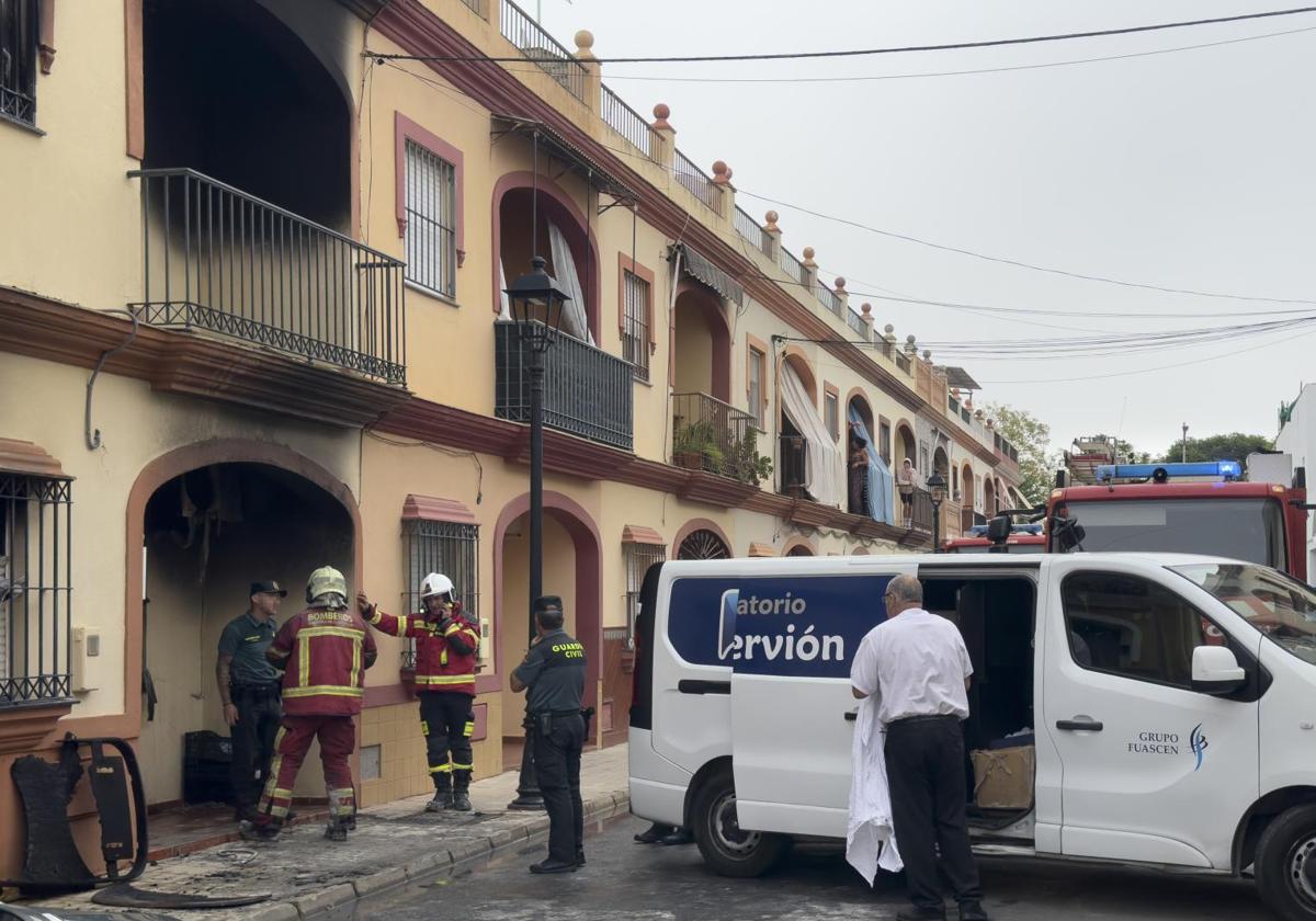 Servicios funerarios y bomberos en la casa donde ha muerto una familia en Sevilla.