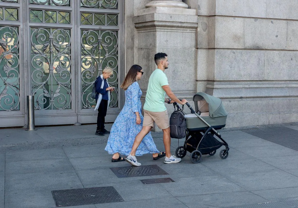 Una pareja pasea con su hijo en Madrid.