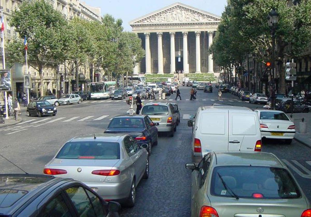 Vehículos transitan por una avenida de París.