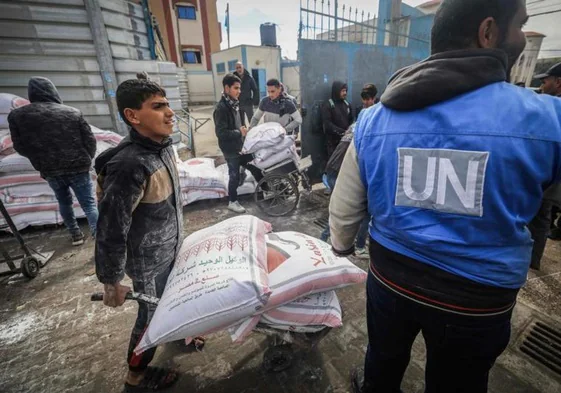 Palestinos desplazados reciben ayuda de la UNRWA en Rafah.