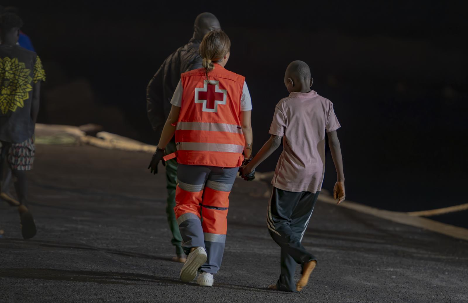 Una trabajadora de Cruz Roja atiende a un menor llegado a El Hierro