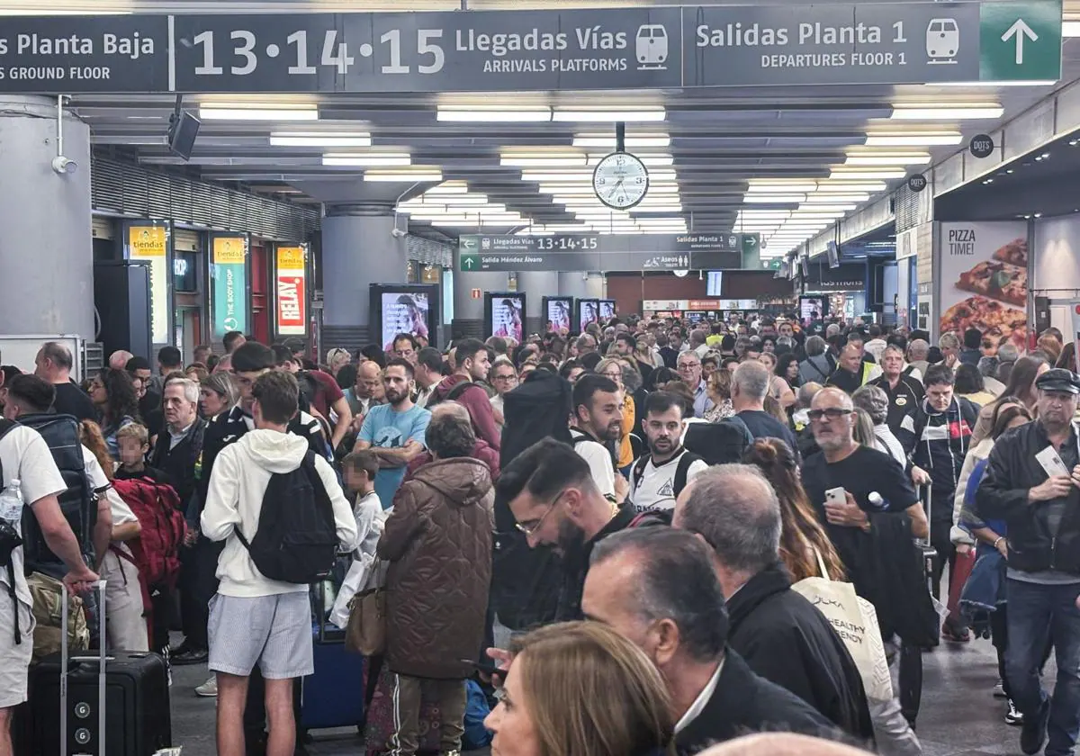 Decenas de pasajeros en el interior de la estación madrileña de Atocha tras cortarse este sábado el tráfico ferroviario en la zona.