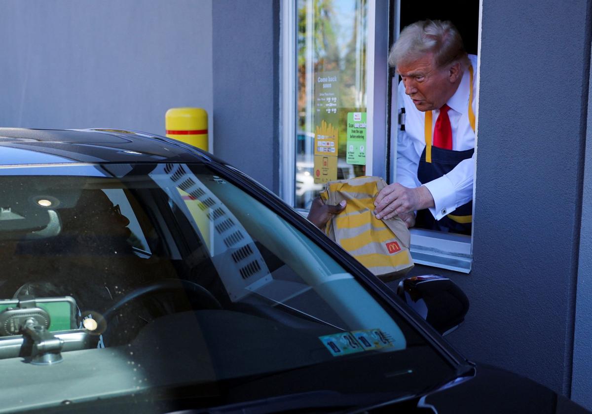 El candidato republicano, Donald Trump, sirve comida en un McDonald's.