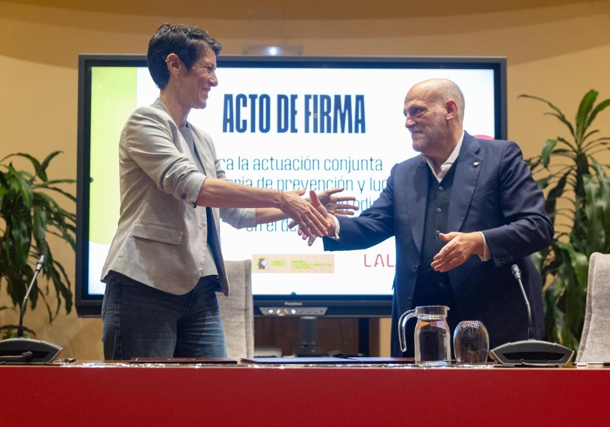 La ministra Elma Saiz y Javier Tebas se saludan tras la firma del acuerdo contra el racismo.