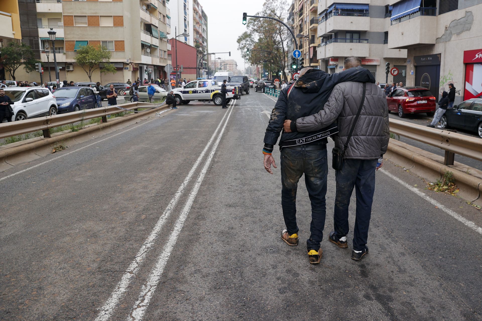 Dos personas abandonan el barrio de La Torre de Valencia, uno de los barrios periféricos de la zona sur que sufre inundaciones