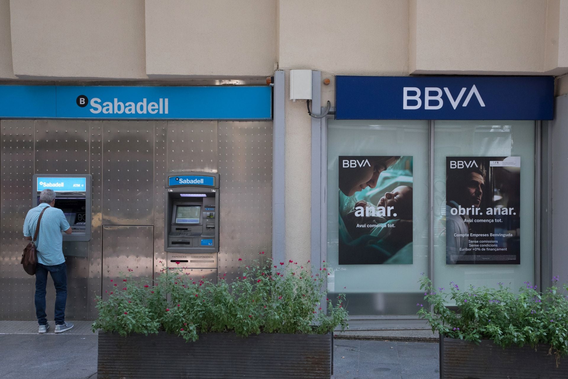 Un cajero de Banco Sabadell junto a otro de BBVA, en Barcelona.