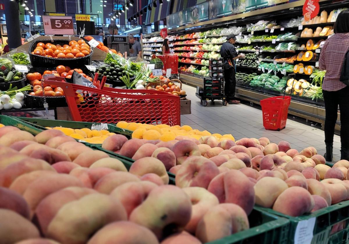 Personas comprando fruta en un supermercado.