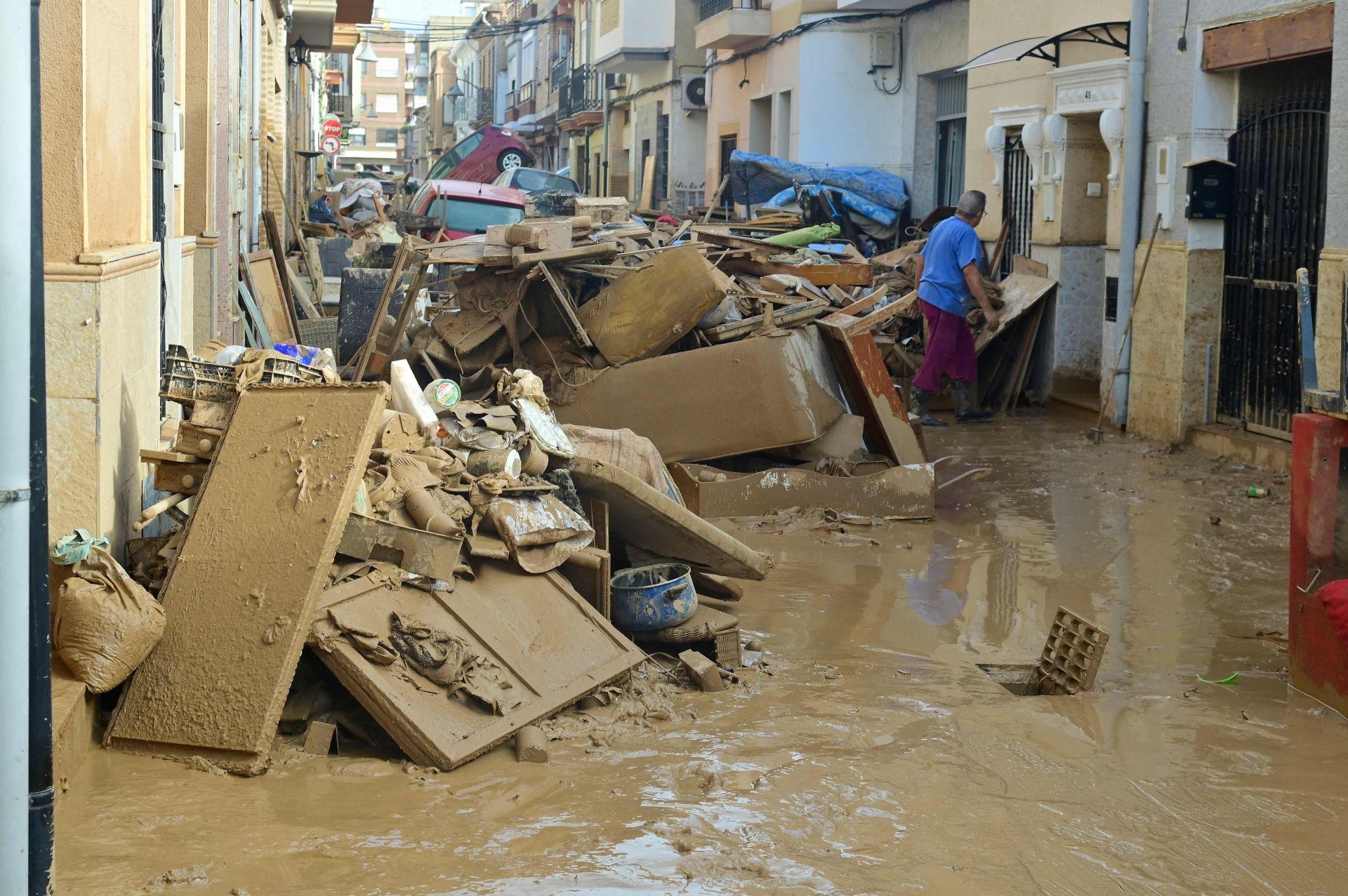 Los residentes intentan limpiar sus casas mientras la calle está cubierta de barro en Alfafar