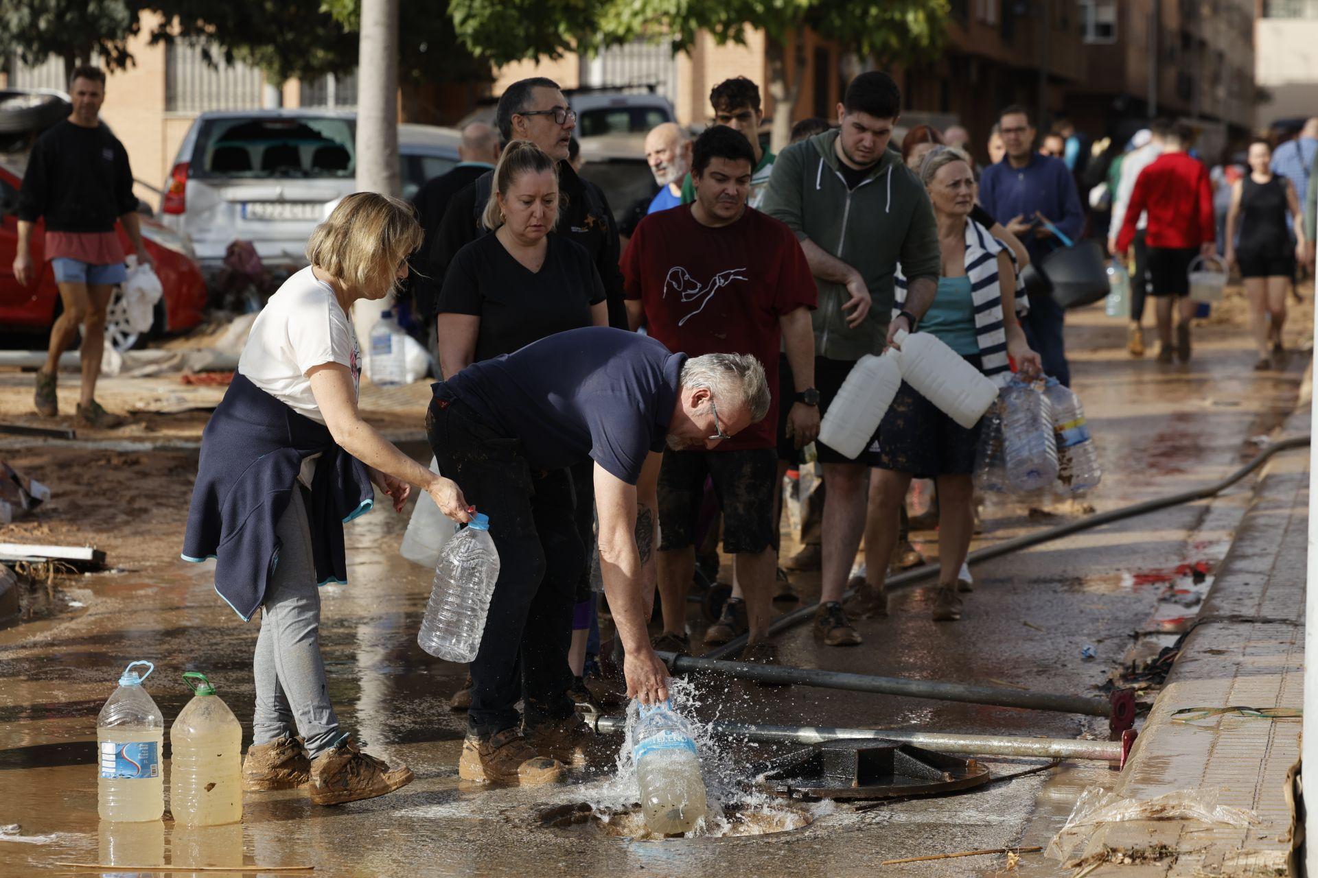 Varias personas toman agua potable de un hidrante en Paiporta, Valencia