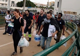 Personas se dirigen con víveres y productos de primera necesidad hacia La Torre desde la pasarela que comienza en San Marcelino