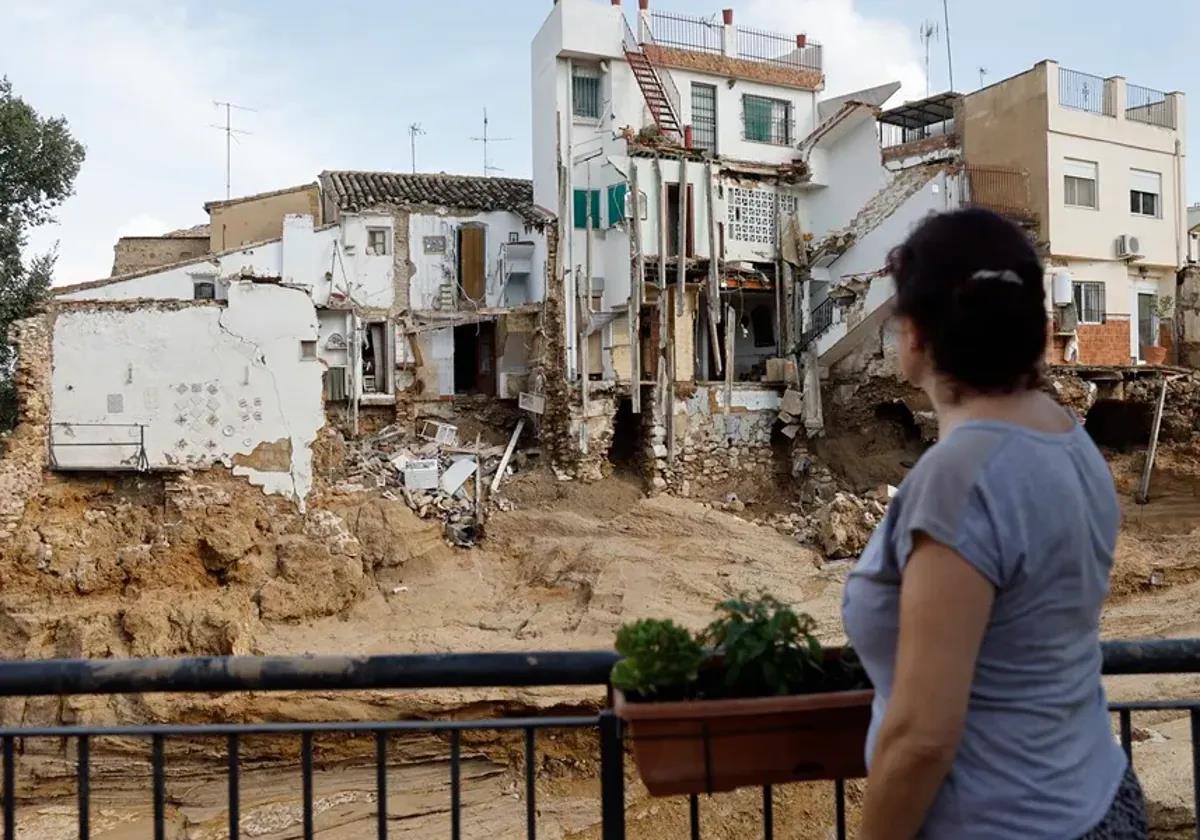 Una vecina observa un edificio derruido en Chiva