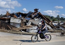 Un ciclista pasa por delante de un edificio arrasado hace unas semanas por 'Helene' en Asheville.