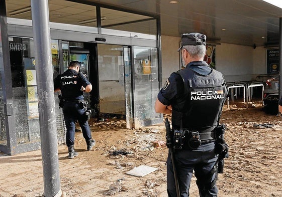 Policías nacionales vigilan los accesos al centro comercial MN4 en la localidad valenciana de Alfafar, una de las más afectadas por la DANA.