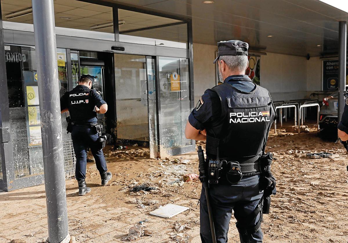 Policías nacionales vigilan los accesos al centro comercial MN4 en la localidad valenciana de Alfafar, una de las más afectadas por la DANA.