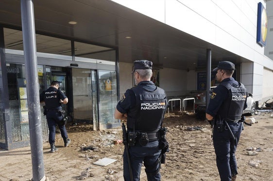 Agente de la Policía Nacional vigilan un comercio en Alfafar (Valencia).