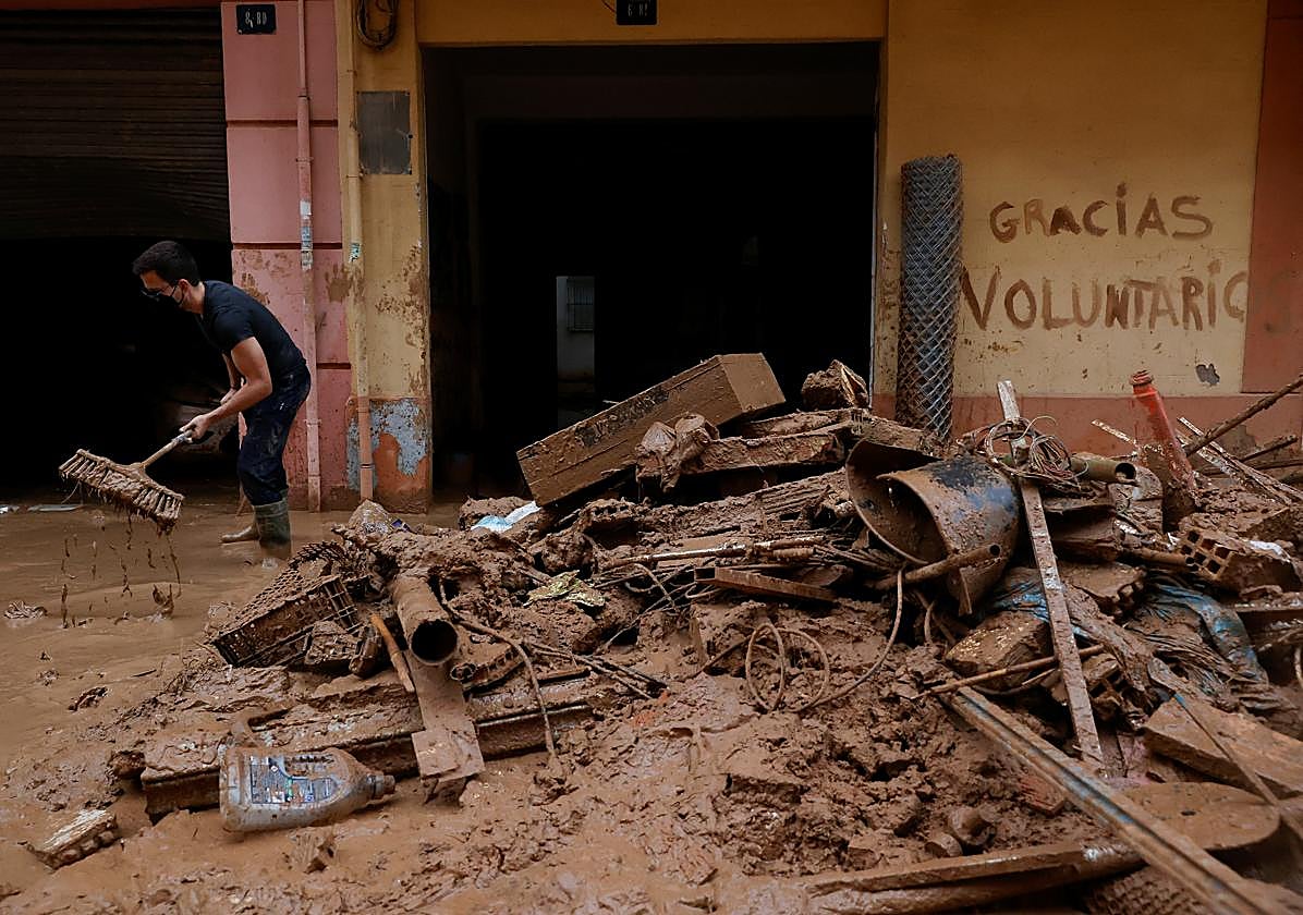 Un voluntario limpia las calles en los municipios afectados en Valencia.
