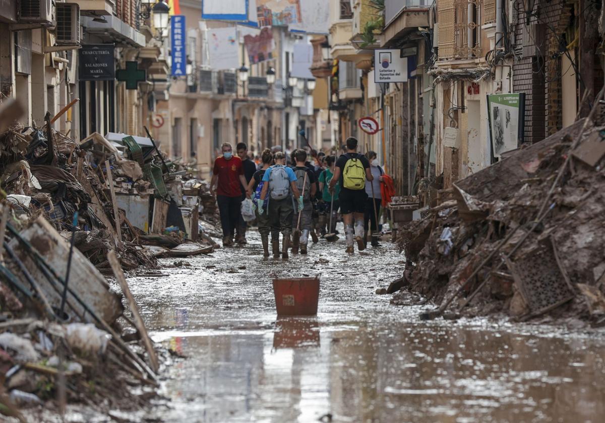 Paiporta, el municipio con más fallecidos intenta limpiar sus calles con la ayuda de voluntarios.