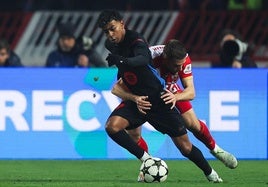 Lamine Yamal, sujetado por un rival durante el duelo ante el Estrella Roja.