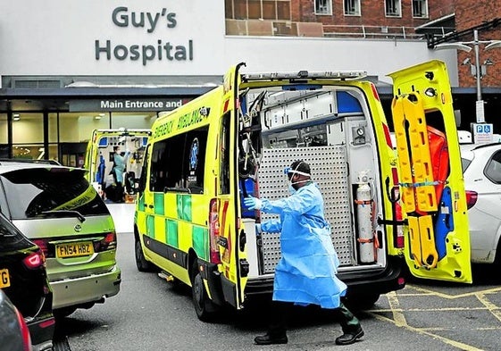 Un médico se dispone a atender a un enfermo evacuado en ambulancia.