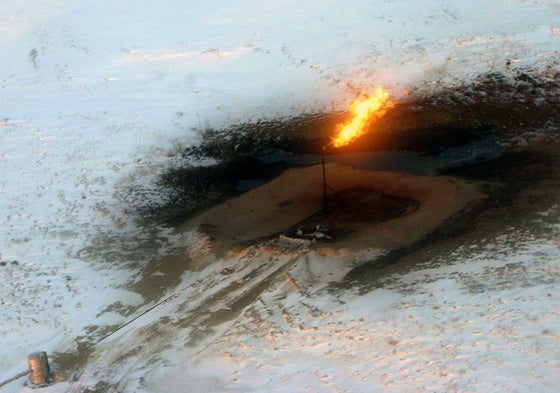 Chimenea exhala fuego en las instalaciones de una refinería de petróleo, en Nadym (Siberia), rodeada de una capa de nieve.