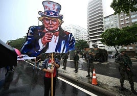 Un manifestante con un cartel con la figura de Trump.