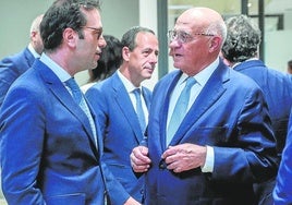 El ministro de Economía, Carlos Cuerpo, charla con el presidente del Sabadell, Josep Oliu.