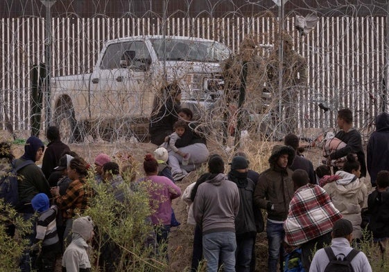 Decenas de migrantes aguardan al otro lado de la valla en El Paso, Texas.