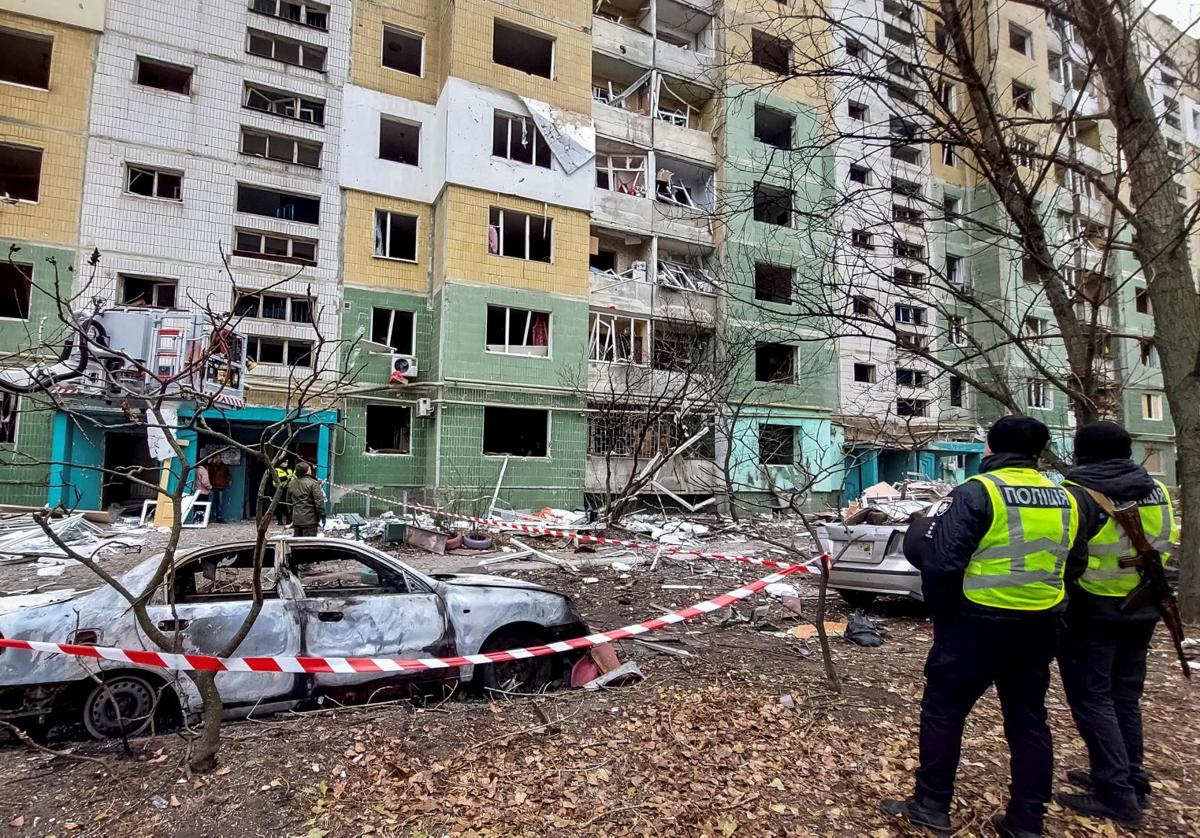 Dos agentes de policía observan los daños causados por un misil ruso en un edificio de la ciudad de Sumi.