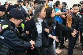 La policía hongkonesa detiene a una mujer que se manifestaba a las puertas del tribunal durante el juicio a los 45 activistas prodemocracia.