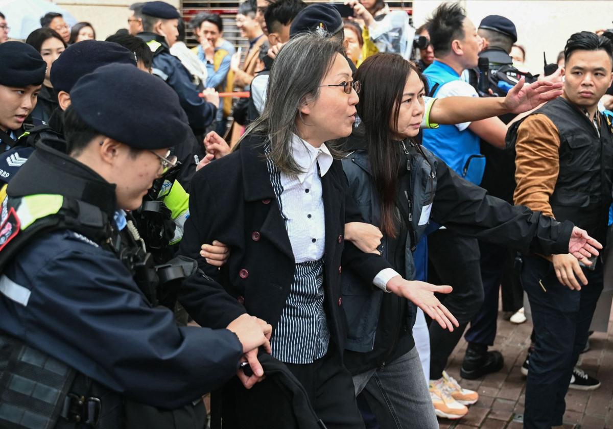 La policía hongkonesa detiene a una mujer que se manifestaba a las puertas del tribunal durante el juicio a los 45 activistas prodemocracia.