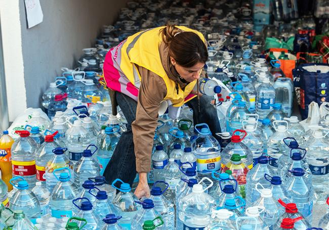 Una voluntaria organiza las donaciones ciudadanas de agua en un punto de recolección de Valencia para distribuirla en las localidades afectadas por la Dana