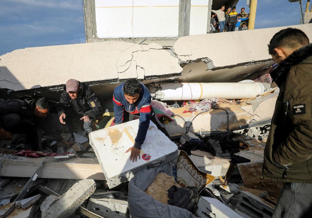 Civiles revisan los daños producidos en una escuela convertida en un centro de refugiados tras los ataques de este miércoles.