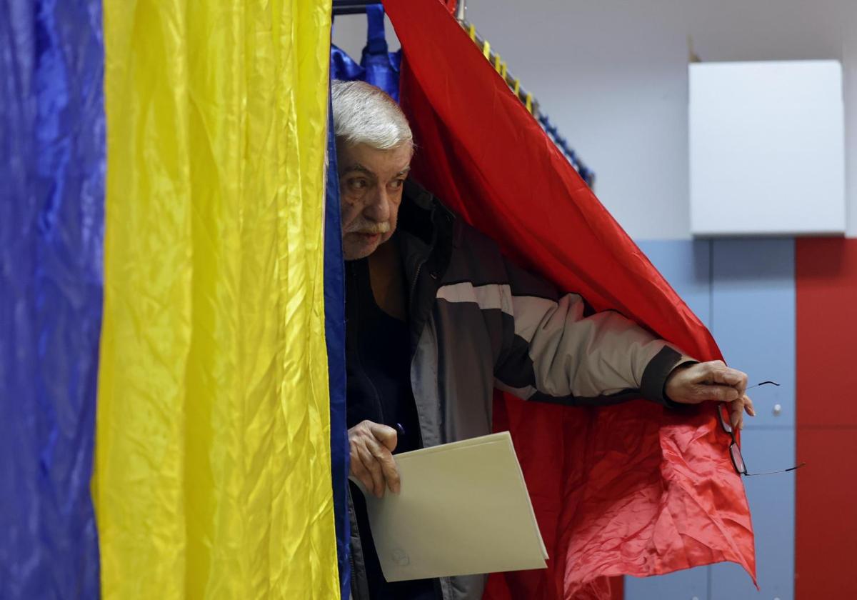 Un elector, en una cabina de votación en Bucarest.