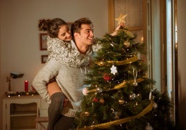 Disfrutando de la navidad en familia con árbol de navidad decorado con estrella en la punta.