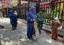 Mujeres afganas caminan con sus hijos por una calle de Kabul.