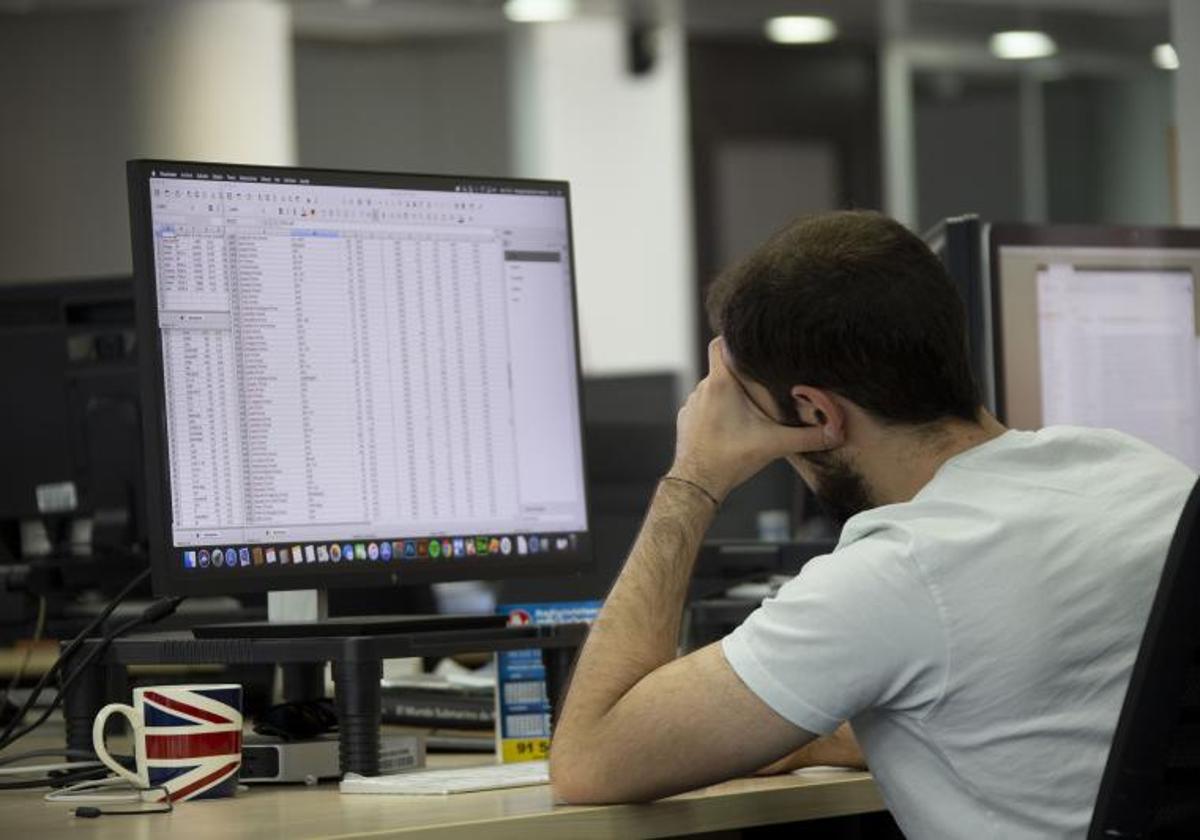 Un trabajador mira la pantalla de su ordenador en la oficina.