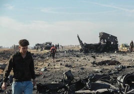 La gente recoge metal y municiones sin explotar en el lugar del ataque aéreo israelí.