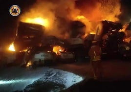 Imágenes del fuego este lunes en una campa de Catarroja (Valencia) llena de coches destrozados por la última dana.