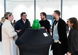 De izquierda a derecha Carmen Figaredo, Hugo Fontela y Guillermo Gauna-Vivas junto a asistentes a la galería junto al Helpi intervenido por Hugo Fontela.