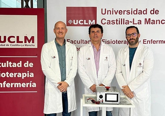 Los tres investigadores posan con el dispositivo de mejora del tratamiento del dolor.