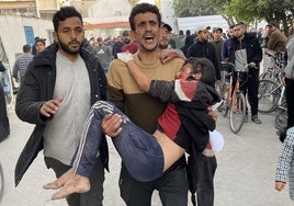 Un hombre ataca a un niño palestino al hospital tras un ataque israelí en Gaza City.