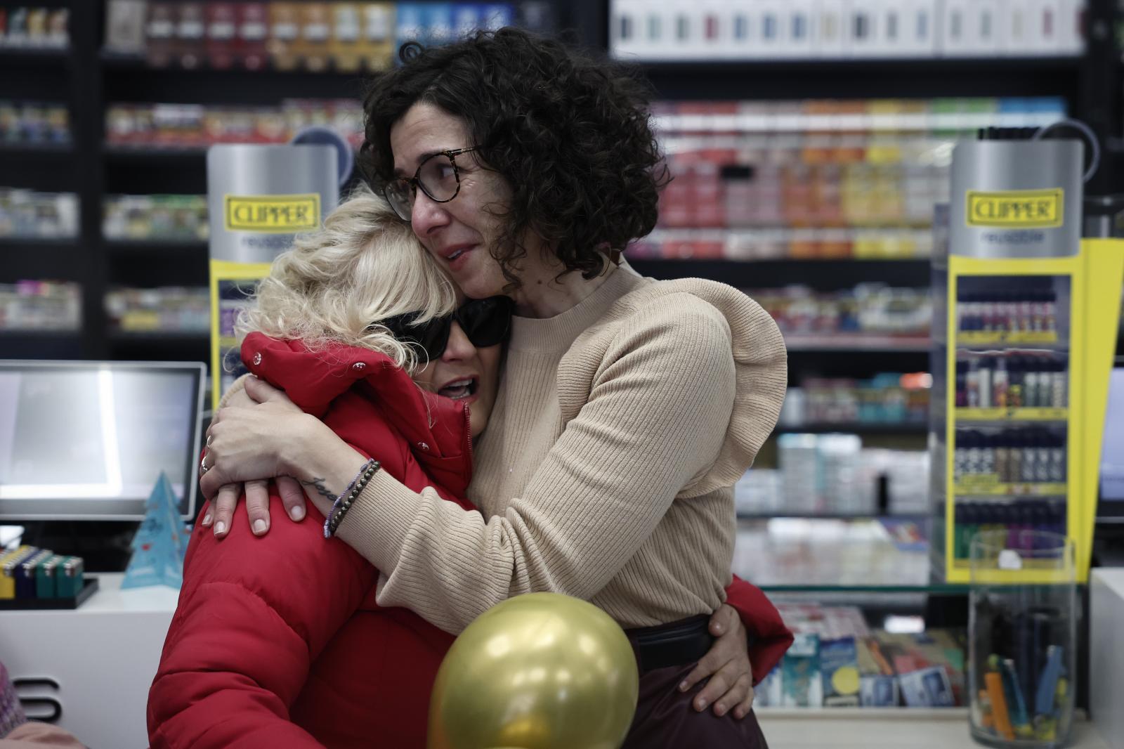 Beatriz Rodríguez, dueña de la administración de San Sebastián de los Reyes que ha vendido parte del número 06766 agraciado con el segundo premio, abraza a Merche, una de sus empleadas. 