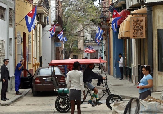 Personas transitan por una calle decorada con banderas de Cuba este miércoles, en La Habana.