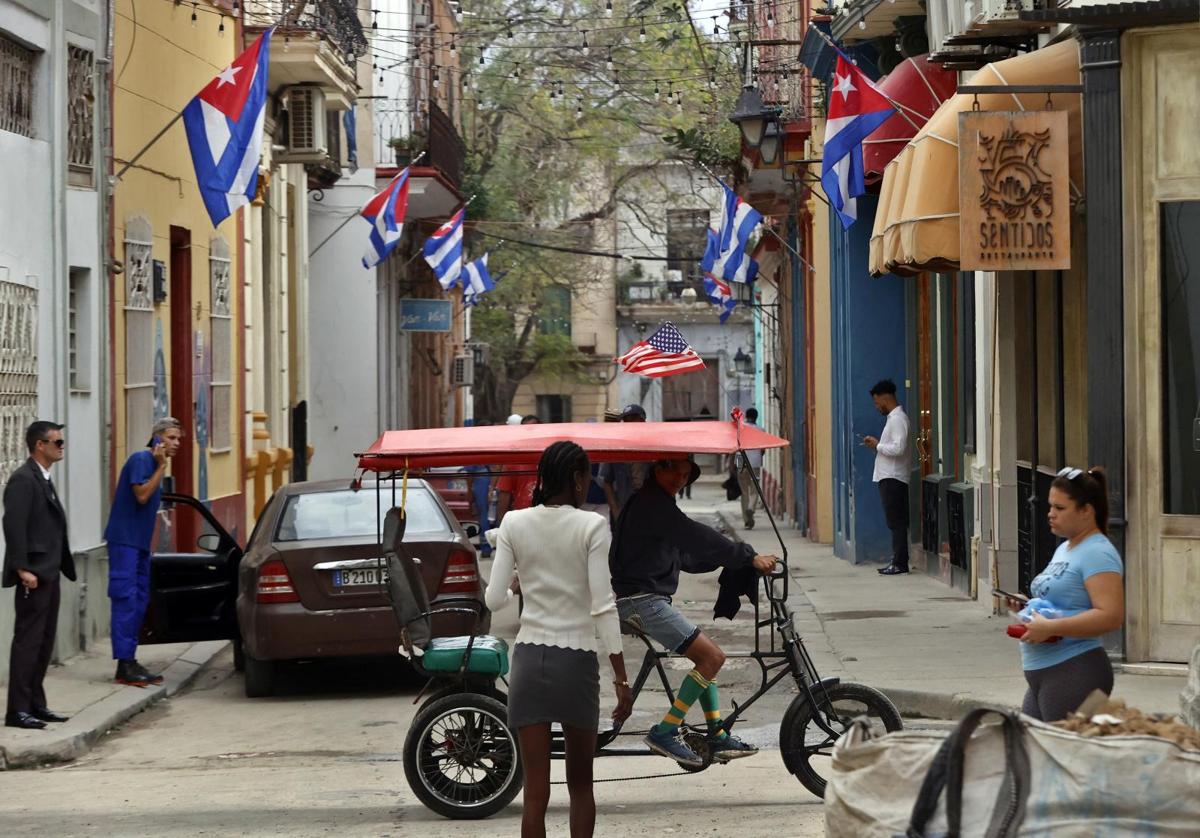 Personas transitan por una calle decorada con banderas de Cuba este miércoles, en La Habana.