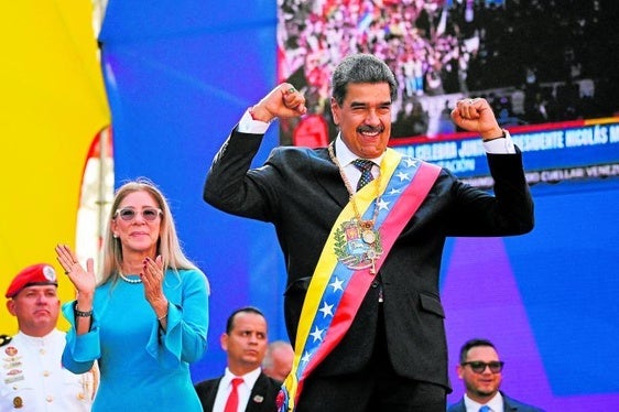 Nicolás Maduro hace un gesto victorioso en su investidura delante de su mujer, Cilia Flores.