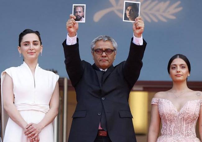 Mohammad Rasoulof en Cannes con las fotos de los actores Soheila Golestani y Missagh Zareh, retenidos en Irán.