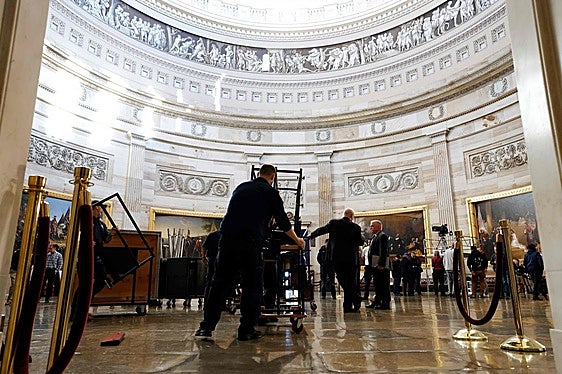 Los operarios y organizadores trabajan en la Rotonda del Capitolio para preparar la juramentación