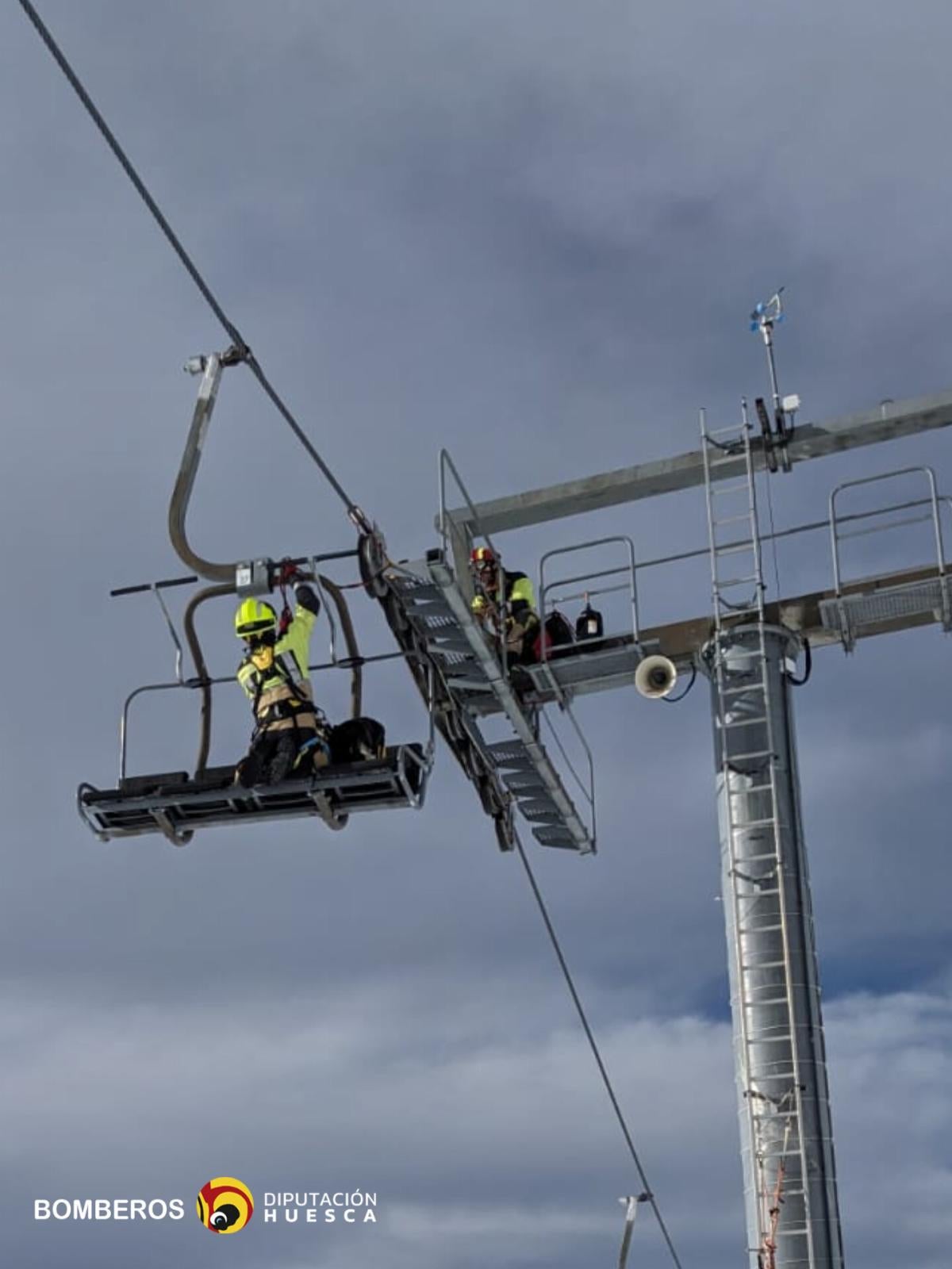 Bomberos de Huesca tratan de reparar el telesilla dañado.