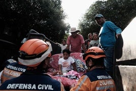 Miembros de la defensa civil trasladan a familias desplazadas por la violencia en la región colombiana de Catatumbo.